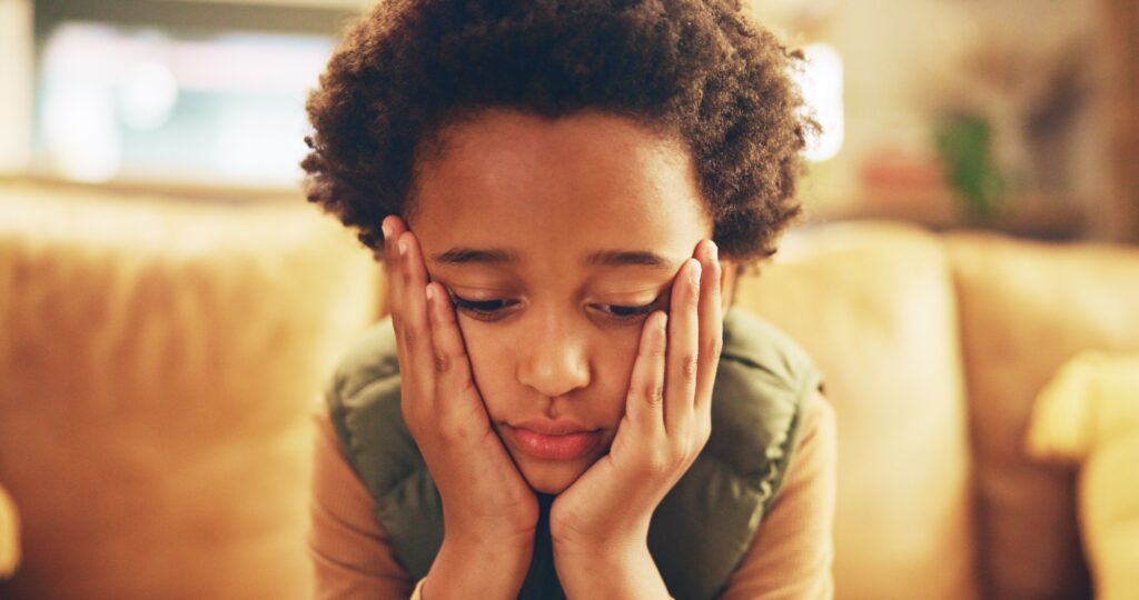 Stress, sad and bored child on couch with mental health, fatigue and frustrated loneliness in home.